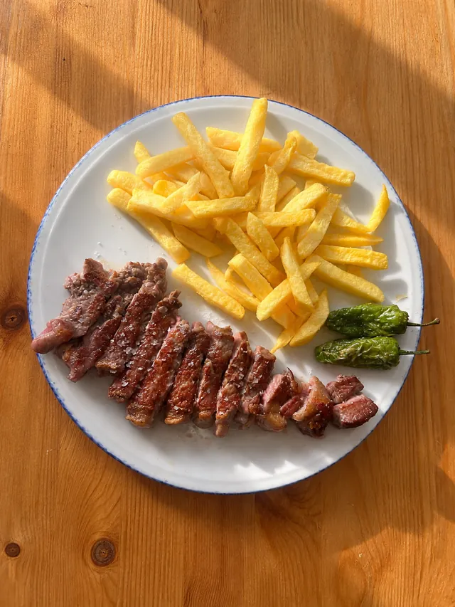 Entrecot a la plancha cortado, con patatas fritas y pimientos