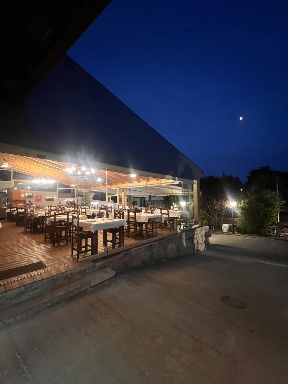 Fachada acristalada del restaurante iluminada al anochecer
