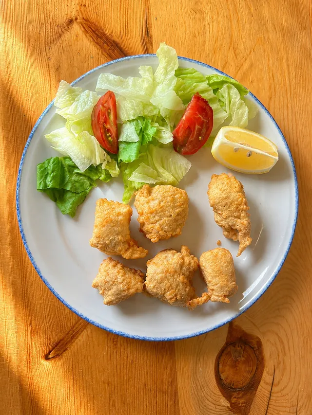 Merluza a la romana con ensalada y limón