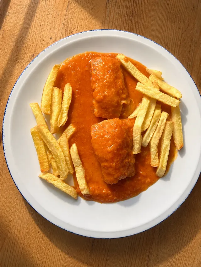Pescado en salsa con patatas fritas